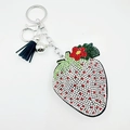 Porte-clés fraise étincelant avec strass et gland en cuir noir sur fond blanc - Blanc