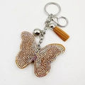 Détail du porte-clés papillon en cristal avec strass irisés et pompon en daim marron - Kaki Foncé