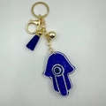Detailed macro view of Hamsa Hand keychain with blue rhinestones and evil eye tassel charm - Hollow Hamsa Hand Style