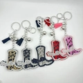 Detail view of five cowboy boot rhinestone keychains with tassels and bells in various colors - Customizable Color