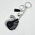 Elegant swan keychain with black and white rhinestones, black tassel, and silver bell charm - Black