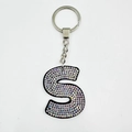 Detail of letter S keychain with rainbow rhinestones on black velvet with silver ring - Letter S