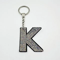 Detail of letter K velvet keychain with colorful rhinestones and silver metal ring - Letter K