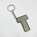 Detail of letter T keychain with sparkling iridescent rhinestones on black base - Letter T