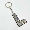 Detail of a velvet letter L keychain with colorful AB crystals and silver ring - Letter L