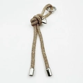 Close-up of champagne gold rhinestone drawstring charm with silver heart pendant and ring - Champagne