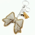 Close-up of rhinestone bow keychain with light brown suede fringe and silver metal clasp - Dark Khaki