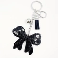 Dettaglio del portachiavi a fiocco nero con strass brillanti e nappa in pelle scura - Nero