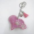 Close-up of pink rhinestone heart keychain with white paw print and soft suede tassel - Pink