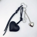 Close-up of black PU leather heart keychain with rhinestone letter S and metal heart - S