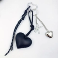 Close-up of heart-shaped PU leather keychain with rhinestone letter K charm and woven cord - Letter K