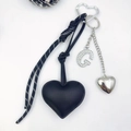 Detail of black PU leather heart keychain with rhinestone letter G and woven cord - Letter G