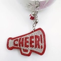 Macro detail of red megaphone keychain with rhinestones, CHEER lettering and red tassel - Red