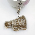 Detail of megaphone shaped keychain with CHEER rhinestones and silver metal hardware - White and Khaki