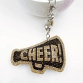 Detailed close-up of a rhinestone megaphone keychain with CHEER text and silver bell - Khaki with Black