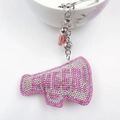 Detailed macro view of pink rhinestone megaphone keychain with tassel and bell - Pink