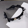 Dettaglio di elegante cerchietto nero con fiocchi in rete, perle e centro in strass - Nero