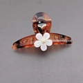 Elegant tortoiseshell hair claw clip with white flower detail and amber brown pattern - Amber