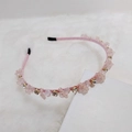 Diadema rosa tejida a mano con cuentas de cristal y pedrería sobre fondo de felpa blanco - Rosa