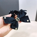 Elegante goma de pelo con lazo negro, emblema dorado y brillantes colgantes de cristal - Negro