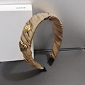 Dettaglio del cerchietto in raso kaki arricciato con cuori dorati e accenti metallici - Marrone
