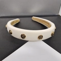 Detailed macro view of white padded camellia headband with vintage gold rose ornaments - Fabric Beige Style
