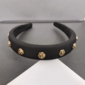Close-up of padded black satin headband with vintage golden 3D metal roses - Fabric Black Style