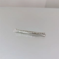 Gedetailleerde close-up van een zilveren haarspeld met rijen sprankelende witte steentjes - Zilver
