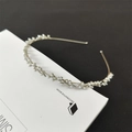 Detail eines silbernen Metall-Haarreifs mit weißen Perlen im eleganten Zweig-Design - Silber