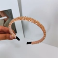 Detailed close-up of champagne crystal beads on a pink silk headband with end protection - Champagne