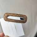 Close-up of brown PU leather hair clip with diamond lattice stitching and hand-stitched edges - Camel