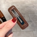 Détail d'une barrette en cuir PU marron avec coutures et attache en métal noir - Brun Foncé