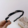 Detail showing hand holding a black twisted fabric headband with sparkling silver crystals - Black
