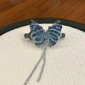 Dettaglio del fermaglio per capelli a farfalla blu ricamato con nappe di cristallo e metallo - Fermaglio a Molla Farfalla Nappa