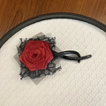 Détail d'une rose en satin rouge faite à la main et dentelle noire sur pince à cheveux - Style Fleur C