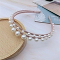 Detalle de diadema rosa de doble capa con elegantes perlas blancas sobre mármol suave - Rosa
