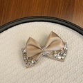 Detail of champagne satin bow hair clip with sparkling rhinestones and crystal accents - Khaki