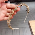 Detail of golden metal headband featuring champagne leaf-shaped rhinestones and crystals - Champagne