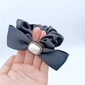 Dettaglio scrunchie in seta grigia con perla rettangolare e fiocco di strass lucidi - Nero
