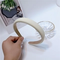 Macro view of cream-colored thick sponge headband with soft fabric texture and minimal design - White