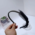 Dettaglio ravvicinato di un cerchietto nero sottile con strass e un delicato fiocco in rete - Fiocco in Maglia Nero (B0283) / Nero