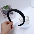 Close-up of a thick black sponge headband made of matte fabric for a volume-boosting look - Black