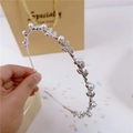 Dettaglio del cerchietto in metallo argento con perle bianche e foglie sottili - Argento