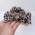 Détail du chouchou à motif léopard avec nœud et boucle en strass scintillants - Chouchou léopard clair