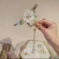 Detailed close-up of golden hair claw with white flowers and long tassel pendants - Style C Tassel