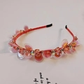 Primer plano de diadema rosa naranja con lentejuelas translúcidas y pedrería brillante - Rojo
