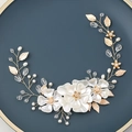Elegante cerchietto da sposa con fiori bianchi, foglie dorate e perle su piatto blu - Oro