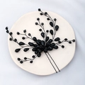Macro shot of black beaded wedding hair pin with faceted crystals on a ceramic plate - Handmade Beaded Branch Style / Black