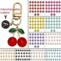 Détail du porte-clés cerise rouge avec pendentif lettre A et options multicolores - Style Lettre Cerise Rouge Transparent