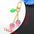Close-up of strawberry keychain with 9cm length dimensions and resin fruit pendant - Transparent Pink Leaf Strawberry